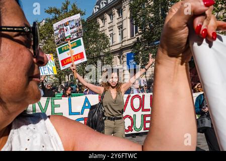 Una donna alla fine della manifestazione con un cartello, Woman Life Free, un movimento internazionale per l'emancipazione femminile. Davanti allo striscione, lunga vita alla rivoluzione democratica in Iran. Donna vita libertà. Manifestazioni in occasione di due anni dall'assassinio di Jina Mahsa Amini, avvenuto il 16 settembre 2022 a Teheran, e per sostenere il popolo iraniano nella sua ricerca della libertà, della laicità e della democrazia. Francia, Parigi, 15 settembre 2024. Foto di Patricia Huchot-Boissier / Agence DyF. Foto Stock