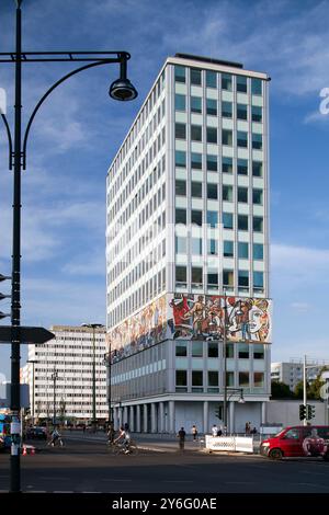 Visita l'iconica Haus des Lehrers di Berlino, adornata dal vibrante murale socialista di Walter Womacka, che mostra una ricca storia culturale. Foto Stock