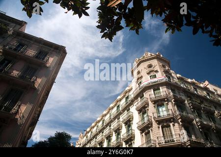 L'architettura storica si ispira a Carrer Gran de Gracia, mostrando dettagli intricati su un vivace cielo blu nel quartiere di Gracia. Foto Stock