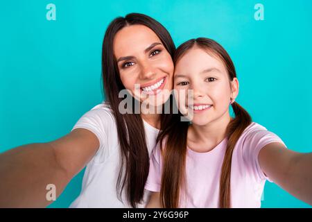 Foto di una ragazza adorabile con mamma che scatta selfie con amore e armonia isolati su sfondo di colore ciano Foto Stock