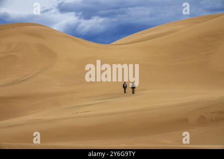 Due viaggiatori nel deserto. Escursioni sulle dune di sabbia in montagna. Deserto del Gobi, Mongolia, Asia Foto Stock