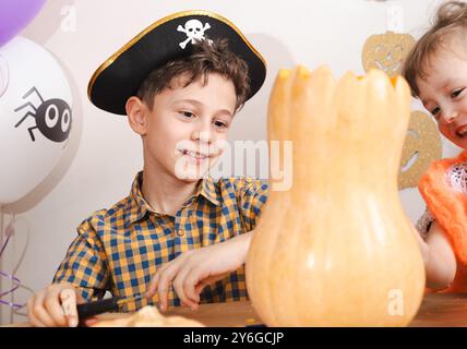 I bambini al laboratorio di Halloween imparano a intagliare le zucche per le decorazioni natalizie Foto Stock