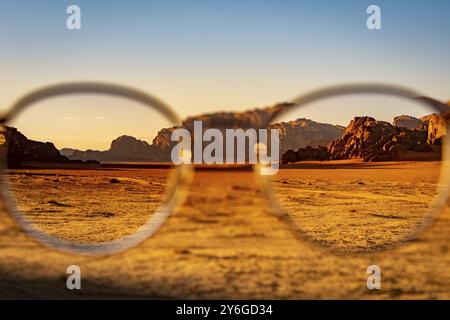 Ammira il deserto di Wadi Rum in Giordania attraverso gli occhiali durante un bel tramonto con cielo limpido. Viaggi, turismo e avventura Foto Stock