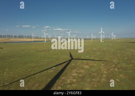 Vista aerea di mulini a vento o turbine eoliche e ombre sulla centrale eolica in rotazione per generare energia elettrica Foto Stock