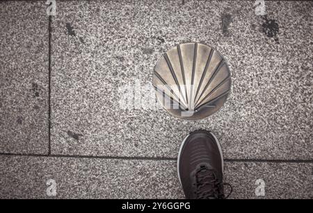 Lugo, Spagna, 6 settembre 2023: Direttamente sopra il colpo di scarpa da trekking e il guscio di camino Santiago de Compostela St James, Europa Foto Stock