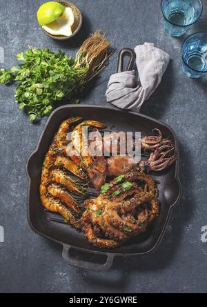 Cibo, cibo, spille grigliate, calamari e polpi nella teglia in ghisa Foto Stock