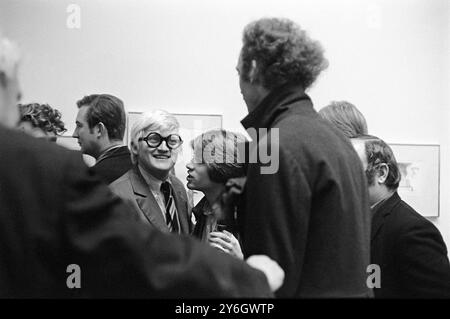 David Hockney. Hockney con il suo amico Peter Schlesinger che gli sussurra. R B Kitaj (all'estrema sinistra si vedono solo le sopracciglia, e Peter Blake appena a metà testa dietro Patrick Procktor (alto cappotto scuro) la festa di apertura di Hockney alla Kasmin Gallery, Bond Street London di "Recent Etchings". Inghilterra dicembre 1969 1960s Regno Unito HOMER SYKES Foto Stock