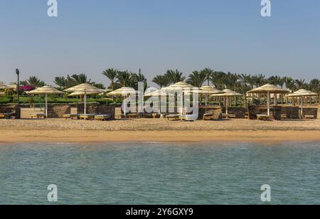 Spiaggia vuota con lettini e ombrelloni. Resort Coast senza persone, concetto del crollo dell'industria turistica. La costa del mare è vicina a. Foto Stock