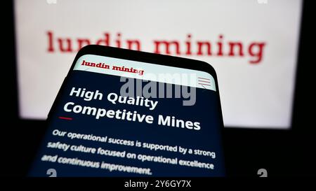 In questa immagine, davanti al logo aziendale è visibile un telefono cellulare con il sito Web della società canadese Lundin Mining Corporation. Foto Stock