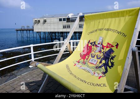 Aberystwyth, Galles, Regno Unito - 6 settembre 2024; sdraio sovradimensionato con stemma e molo del comune di Aberystwyth Foto Stock