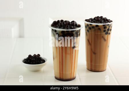 Due tazze di plastica di tè al latte di Boba di Taiwan su sfondo bianco Foto Stock