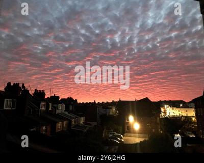 Vista del tramonto su un quartiere residenziale con un cielo spettacolare pieno di nuvole illuminate dal tramonto. Foto Stock