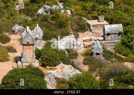 Vista ravvicinata di molte tombe in pietra di Licia sulla terra a Kalekoy, Kekova, Antalya, Turchia Foto Stock