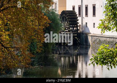 Vista della grande ruota di legno di un mulino ad acqua sul fiume Moldava nella città vecchia di Praga. Una passeggiata in città in un caldo e senza nuvole giorno d'autunno. Foto Stock