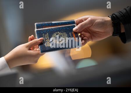 Berlino, Germania. 25 settembre 2024. Un dipendente di un hotel restituisce i pass di viaggio a un ospite dal Brasile dopo aver compilato i moduli di registrazione dell'hotel. A partire dal prossimo anno, il requisito di registrazione dell'hotel è di terminare, almeno per gli ospiti tedeschi. Crediti: Sebastian Gollnow/dpa/Alamy Live News Foto Stock