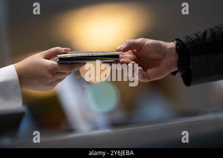 Berlino, Germania. 25 settembre 2024. Un dipendente di un hotel restituisce i pass di viaggio a un ospite dal Brasile dopo aver compilato i moduli di registrazione dell'hotel. A partire dal prossimo anno, il requisito di registrazione dell'hotel è di terminare, almeno per gli ospiti tedeschi. Crediti: Sebastian Gollnow/dpa/Alamy Live News Foto Stock