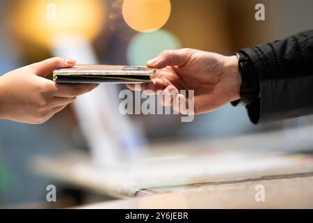 Berlino, Germania. 25 settembre 2024. Un dipendente di un hotel restituisce i pass di viaggio a un ospite dal Brasile dopo aver compilato i moduli di registrazione dell'hotel. A partire dal prossimo anno, il requisito di registrazione dell'hotel è di terminare, almeno per gli ospiti tedeschi. Crediti: Sebastian Gollnow/dpa/Alamy Live News Foto Stock