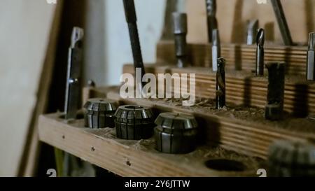 Vari utensili: Lima, cacciavite, martello, pinze, utensili da giardino sono esposti su scaffale in legno all'interno di officine o fabbriche rustiche, officina in una Foto Stock