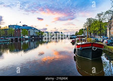 Le case di Amsterdam si riflettono nel canale all'alba Foto Stock