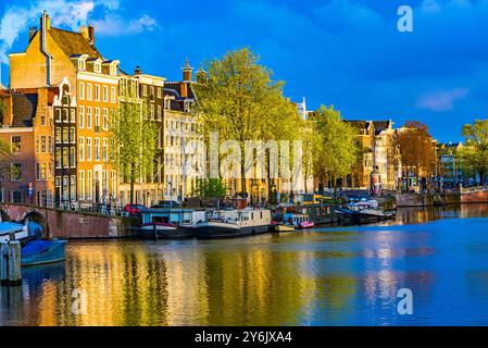 Le case di Amsterdam si riflettono nel canale all'alba Foto Stock