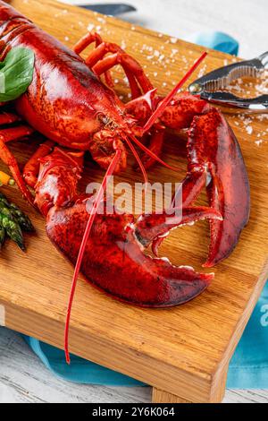 Lussuosa aragosta bollita servita su un piatto di legno con verdure a lato Foto Stock