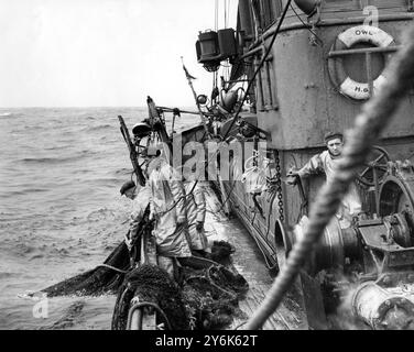 Pescatori a bordo di un peschereccio da traino nel Mare del Nord che trasporta nelle loro reti Foto Stock