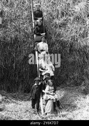 Le donne assistono un contadino del Norfolk con il fieno . Foto Stock