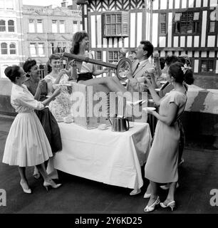 Janet o'Mahoney, ballerina del Palladium londinese seduta su una cassa da tè, ha scelto il tetto del teatro per la sua festa di ventunesimo compleanno con altre ragazze della compagnia danzante, il tè è stato preso sul primo della Gran Bretagna Vaudeville House anche presente alla festa era Max Bygraves il 17 luglio 1959 Foto Stock