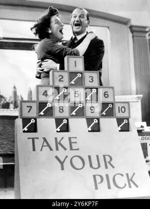 La signora Janice Isaacs di Wembley si congratula con Michael Miles, il compagno del programma ITV "Take Your Pick", dicembre 1955 Foto Stock