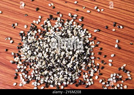 Split Black Lentil conosciuto anche come Black Gram, Black Urad dal, Vigna Mungo, Urad Bean su fondo in legno marrone Foto Stock