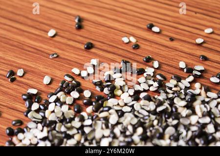 Split Black Lentil conosciuto anche come Black Gram, Black Urad dal, Vigna Mungo, Urad Bean su fondo in legno marrone Foto Stock
