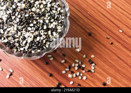 Split Black Lentil conosciuto anche come Black Gram, Black Urad dal, Vigna Mungo, Urad Bean su fondo in legno marrone Foto Stock