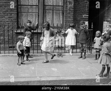 National Playing Fields Association Waterloo Slum District, Londra. I bambini giocano a hopscotch su un marciapiede. Foto Stock