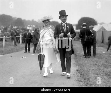 Moda alle gare di Ascot 1920. Gentiluomo che indossa un cappello e una coda, guanti bianchi e gilet. Donna che indossa un cappello e un vestito in piuma bianca. Foto Stock