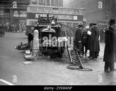 La strada si rompe. Questo motore antincendio, in cerca di evitare un pedone, ha scivolato e si è schiantato in un rifugio a Trafalgar Square, Londra. 7 gennaio 1932 Foto Stock