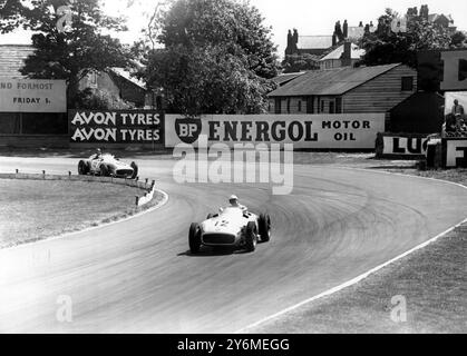 Il pilota inglese Stirling Moss No 12, prende il comando da Fangio dell'Argentina nel terzo giro del Gran Premio di Gran Bretagna ad Aintree. Sia Moss che Fangio guidano Mercedes-Benz il 16 luglio 1955 Foto Stock