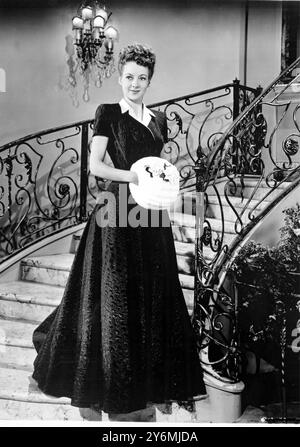 Evelyn Keyes con un ricamato pesantemente in seta, questo straordinario abito blu presenta un colletto in seta color crema applicato in un lungo risvolto destro, mentre la doppia fila di bottoni coordinati alla vita. Con un muffin all'ermellino con motivo rosa color crema. Nella caratterizzazione di Juile, Mrs al Joson nella produzione Columbia "The Jolson Story" un film. Abito di Jean Louis. 23 settembre 1946 Foto Stock