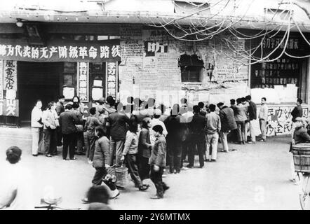 La folla si raduna intorno per leggere i poster in un distretto di Canton, la Cina comunista. I poster raccontano gli ultimi sviluppi della rivoluzione culturale e della lotta per il potere della Cina comunista. 1967 Foto Stock