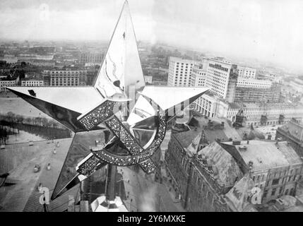 Alle torri del Cremlino di Mosca sono state installate enormi stelle sovietiche a cinque punte al posto delle aquile zariste, ultime reliquie del vecchio regime, che sono state appena rimosse. Le stelle misurano 15 piedi di larghezza e pesano due tonnellate. Portano l'emblema di martello e falce con pietre semi-preziose degli Urali. Sono state usate ottomila gemme su ciascuna. La foto mostra la nuova enorme stella sovietica che sormonta la Torre Nikolsky del Cremlino. A sinistra della stella sono gli edifici dell'Università statale di Mosca e a destra sono i nuovi uffici del Comitato del Consiglio del lavoro e della difesa e t Foto Stock