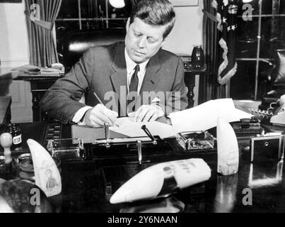 Washington, D.C. USA: Il presidente John F. Kennedy firma la proclamazione che entrerà formalmente in vigore alle 10.00. EDT., la United stated Arms Quarantine contro Cuba. Il Presidente non ha fatto commenti durante la firma. La proclamazione autorizza l'uso delle forze statunitensi per impedire la consegna di armi offensive a Cuba. 24 ottobre 1962 Foto Stock