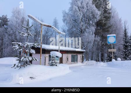 Scandinavia, Lapponia, Finlandia, strada innevata in inverno. Distributore di benzina chiuso. Foto Stock