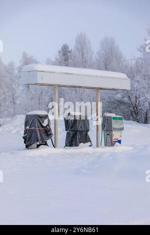 Scandinavia, Lapponia, Finlandia, strada innevata in inverno. Distributore di benzina chiuso. Foto Stock
