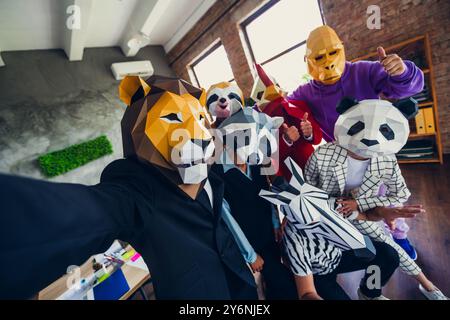 Foto di panda gallo gorilla leone bradipo zebra maschera procione uomini d'affari selfie loft interni ufficio Foto Stock