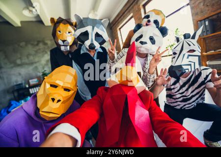 Foto di panda gallo gorilla leone bradipo zebra maschera procione uomini d'affari selfie V-sign loft ufficio interno Foto Stock