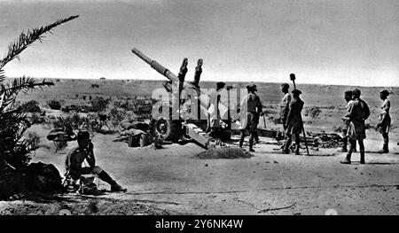 Il telefono sul campo riceve ordini mentre l'equipaggio di un cannone pesante da 4,5 pezzi in azione nel deserto occidentale è in attesa di distruggere più concentrazioni di rifornimenti dell'asse. El Alamein Battlefield ©2004 Topfoto Foto Stock