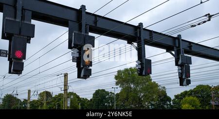 Segnali ferroviari aerei contro un cielo nuvoloso, guidando i treni durante il loro viaggio. Foto Stock