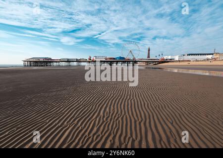 Tranquillo paesaggio marino con un molo di divertimento e una ruota panoramica su un cielo blu limpido. Foto Stock