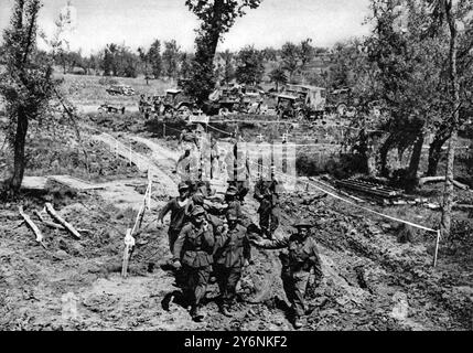 Le prime fasi della grande avanzata alleata in Italia, scene di battaglia dall'area della Valle del Liri. Prigionieri tedeschi presi nell'assalto alla linea Gustav trasportando i propri feriti su barelle in un posto medico alleato. Giugno 1944 Foto Stock