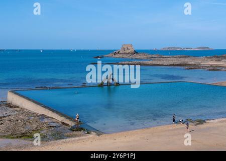 Saint-Malo (Bretagna, Francia nord-occidentale): Piscina di acqua di mare con la sua piattaforma per immersioni sulla spiaggia plage de Bon Secours e sull'isola delle maree Petit Bé nel Foto Stock