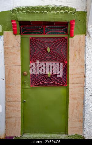 Porta d'ingresso in metallo verde e rosa per una dimora nella Medina, Tangeri, Marocco Foto Stock